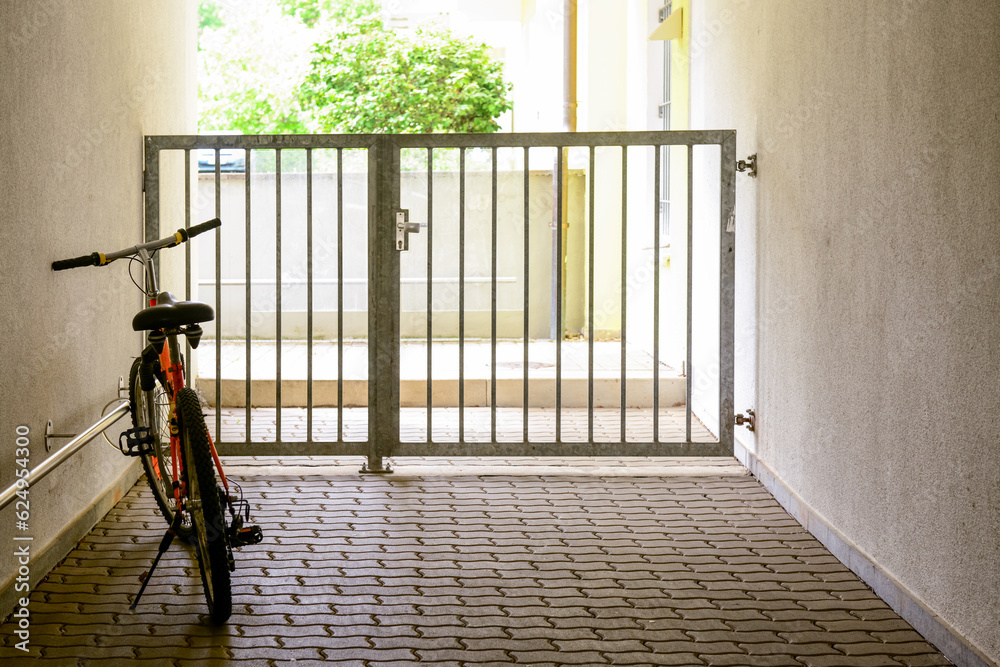 New stylish bicycle near light wall and gate outdoors