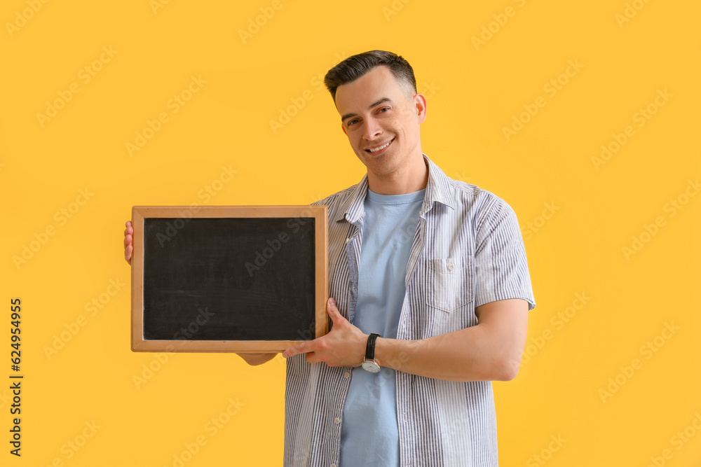 Male teacher with chalkboard on yellow background