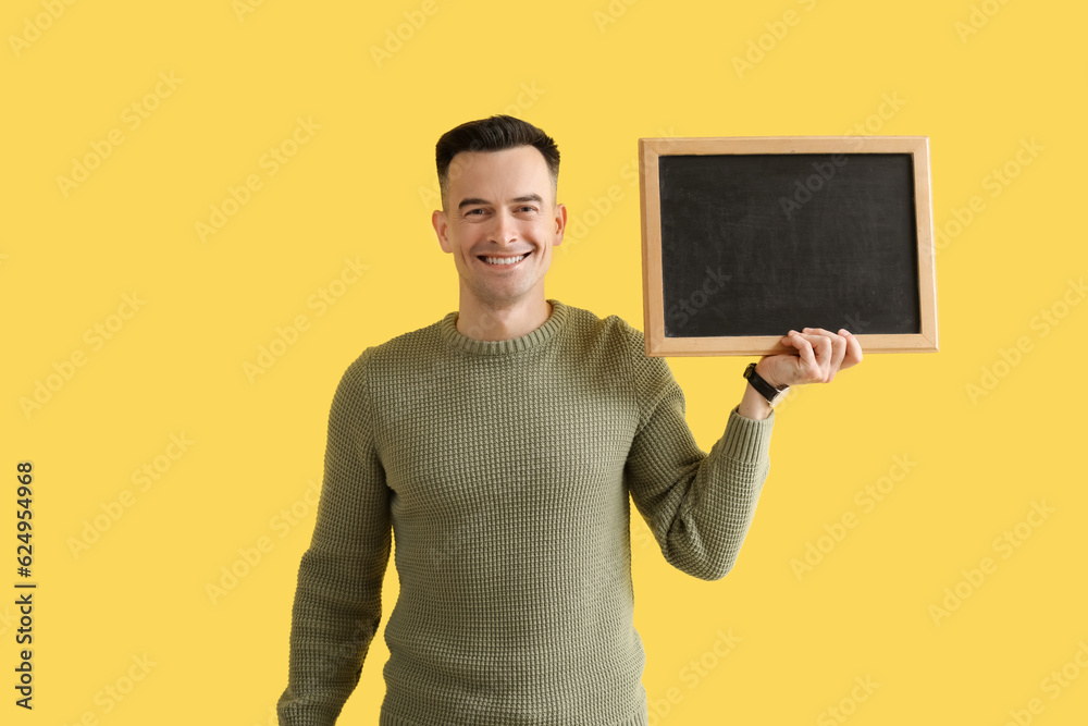 Male teacher with chalkboard on yellow background