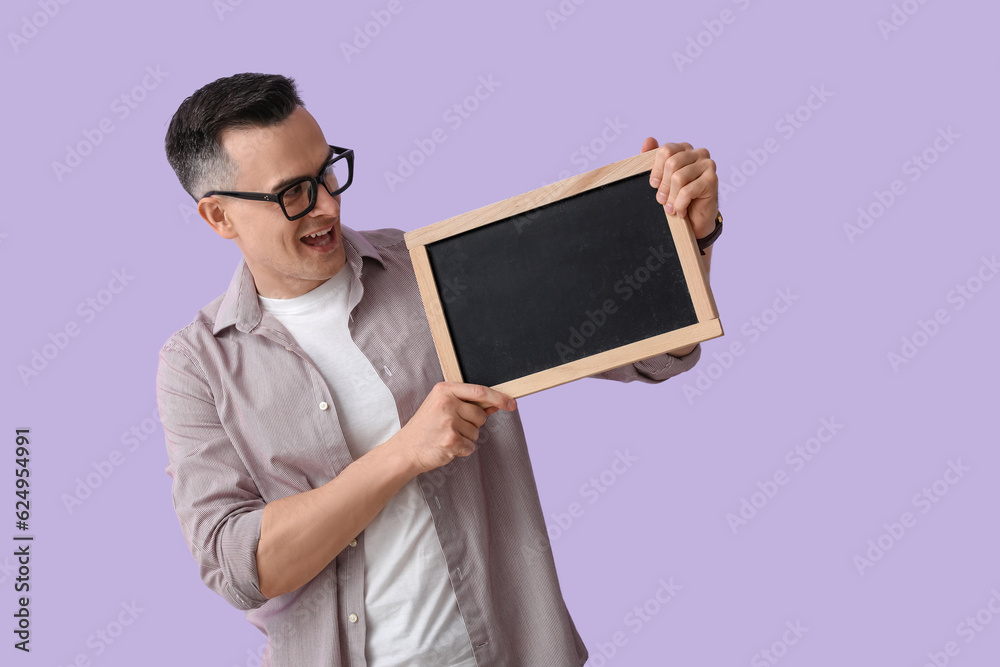 Male teacher with chalkboard on lilac background