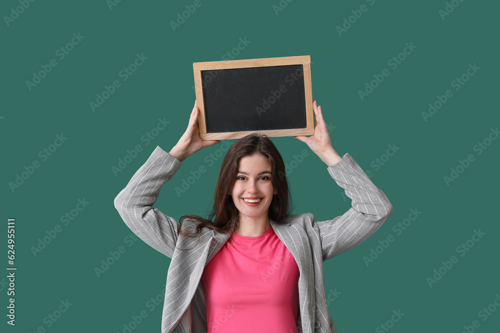 Female teacher with chalkboard on green background