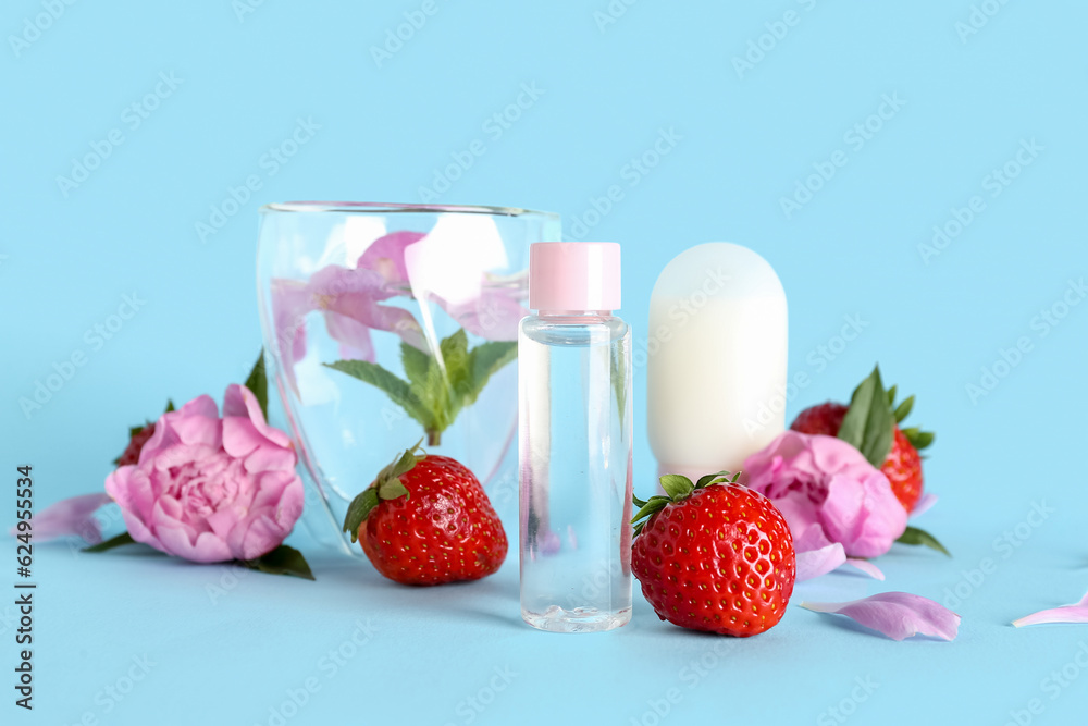 Composition with cosmetic products, glass of water, strawberry and peony flowers on color background