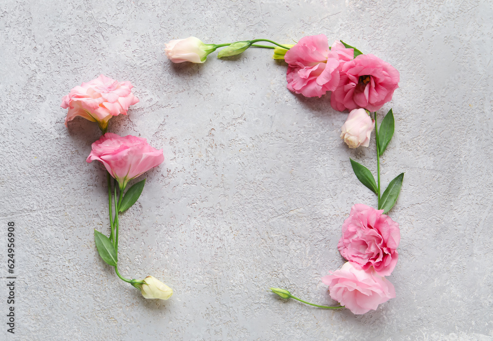 Frame made of beautiful pink eustoma flowers on grey background