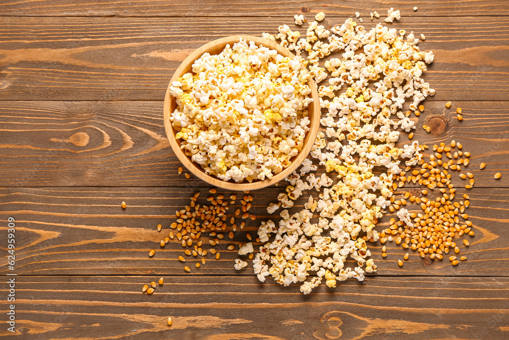 Bowl with tasty popcorn and seeds on wooden background