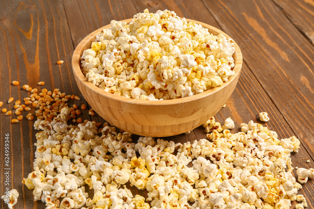 Bowl with tasty popcorn and seeds on wooden background