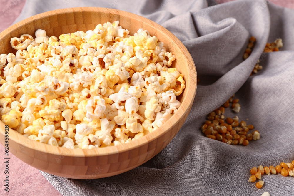 Bowl with tasty popcorn on pink background, closeup