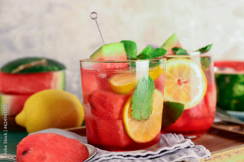 Wooden board with glasses of fresh watermelon lemonade and mint on table, closeup