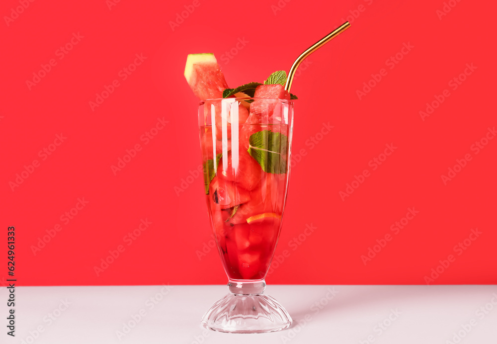 Glass of fresh watermelon lemonade with mint on pink table