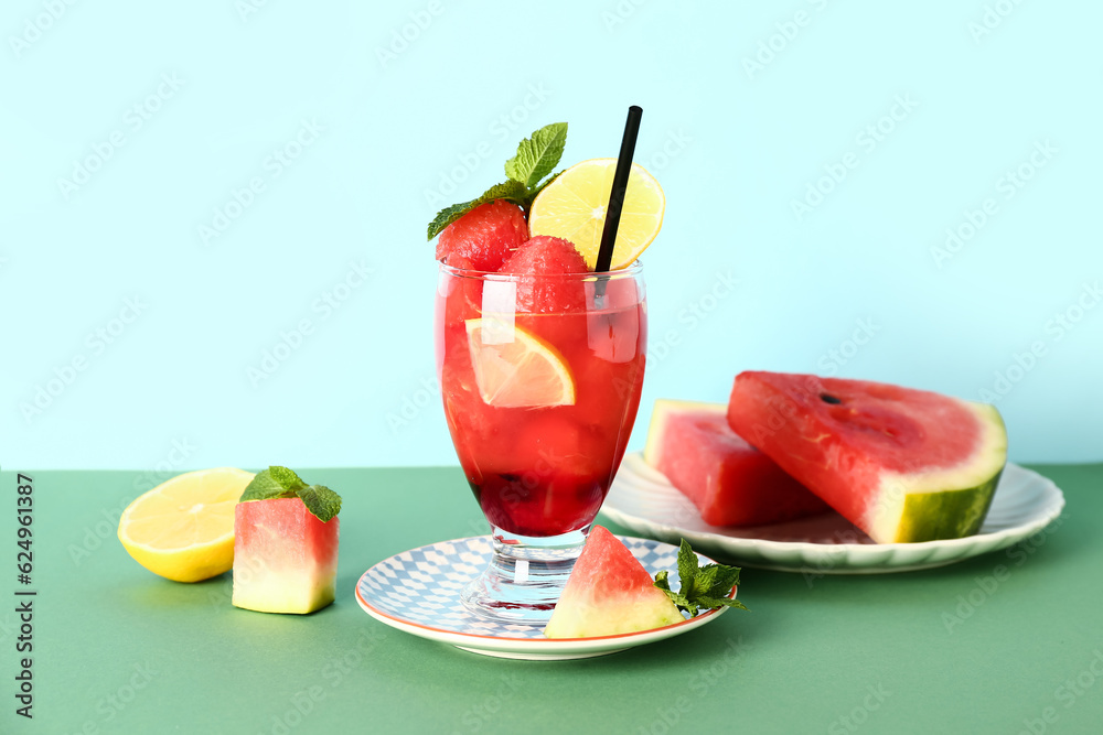 Glass of fresh watermelon lemonade with mint on green table