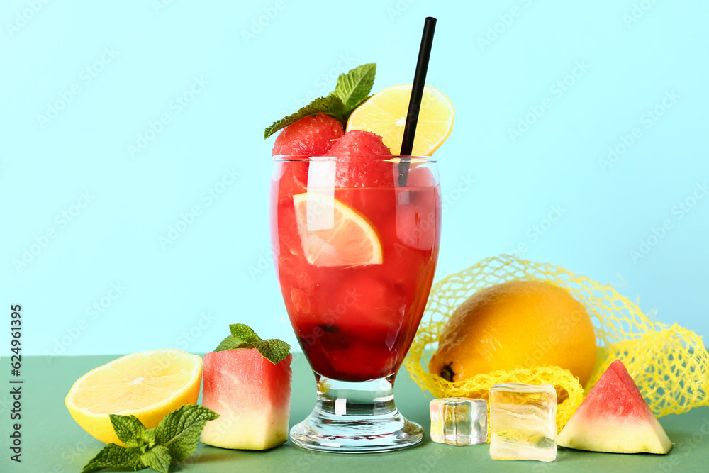 Glass of fresh watermelon lemonade with mint on green table