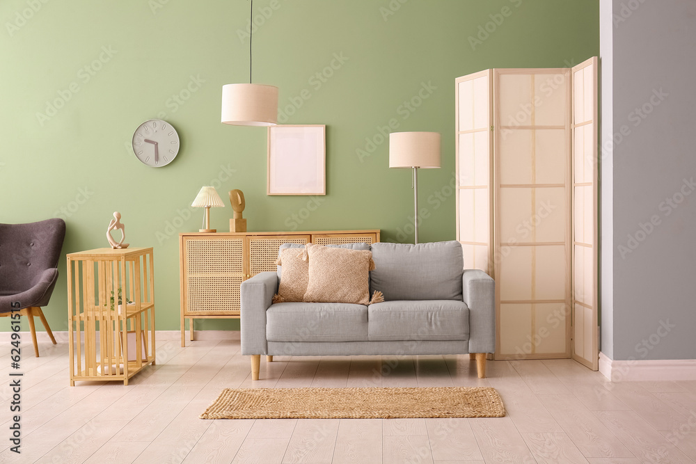 Modern living room interior with grey sofa, cabinet and folding screen