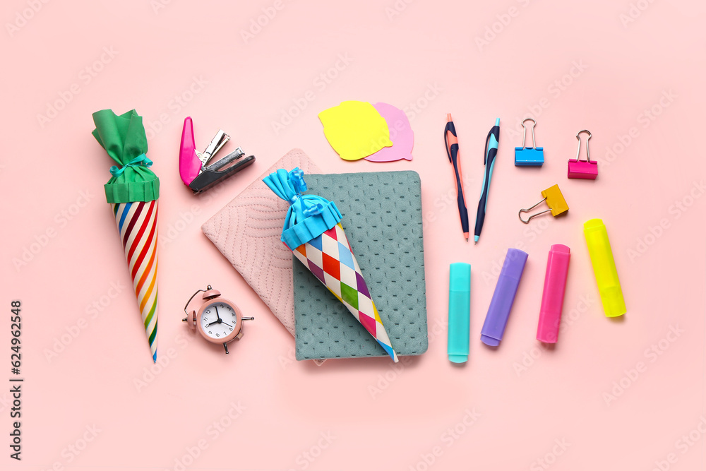 Colorful school cones and stationery on pink background