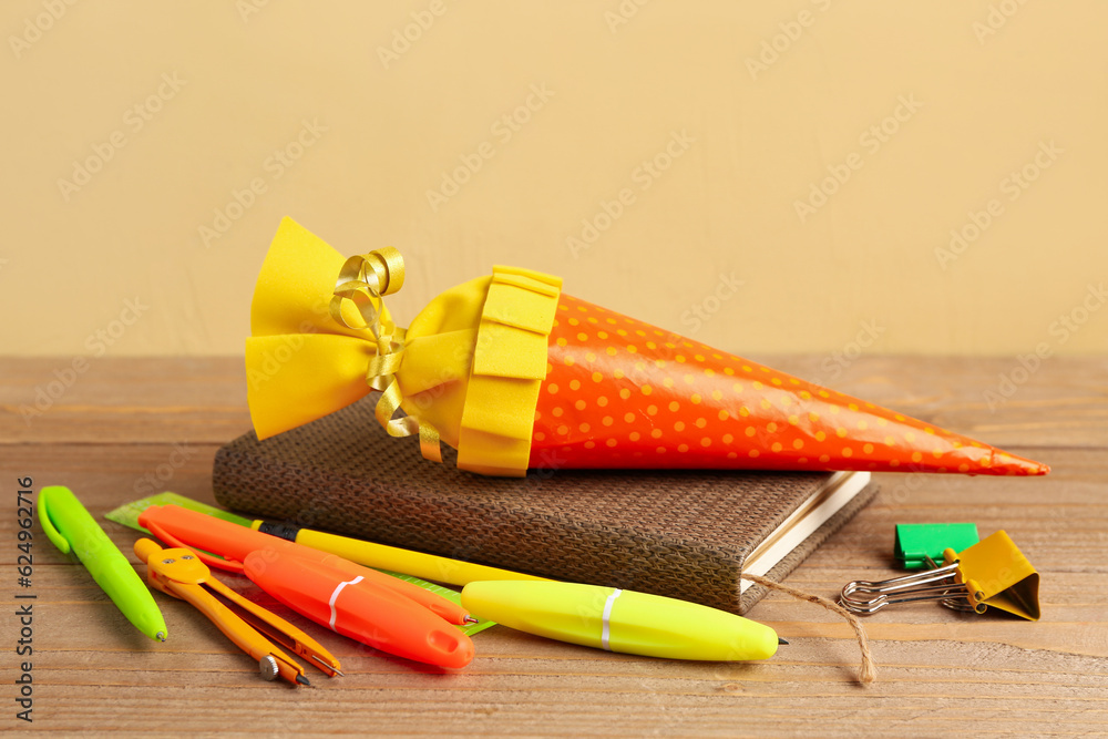 Yellow school cone and stationery on wooden table