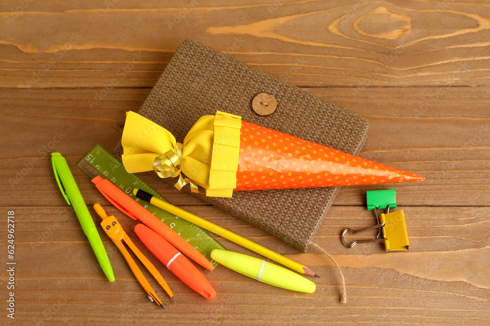 Yellow school cone and stationery on wooden table