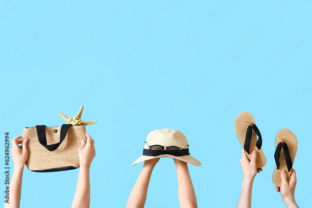 Many hands with beach accessories on blue background