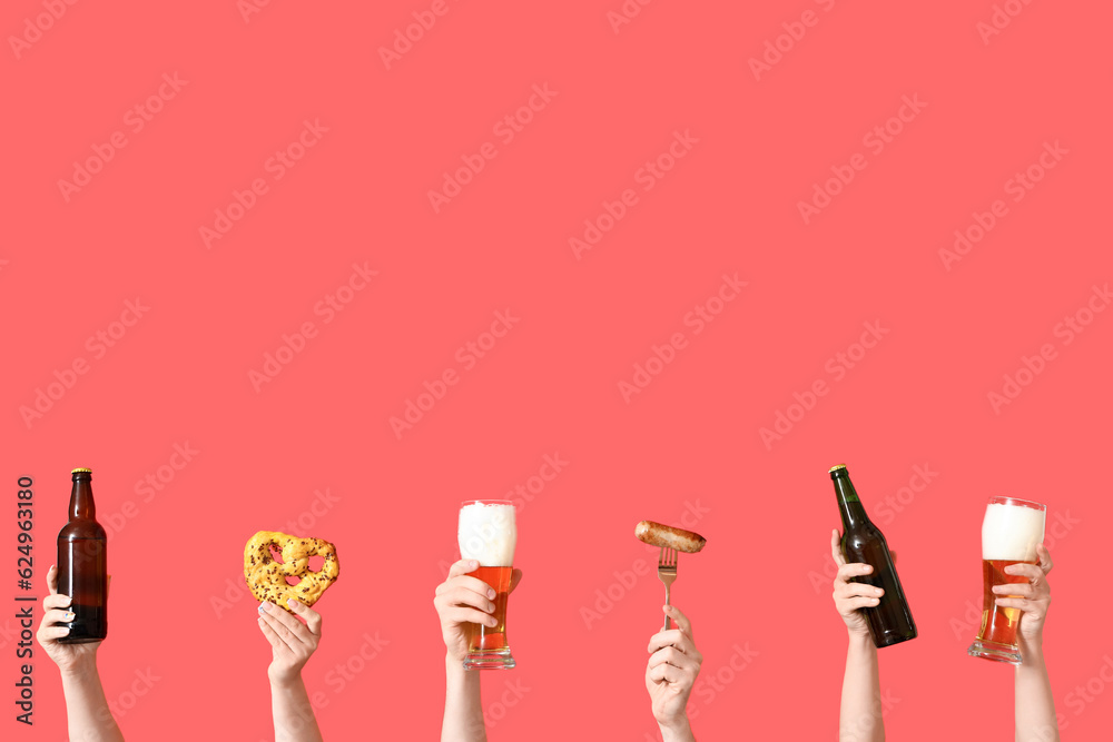 Many hands with cold beer, sausage and pretzel on red background