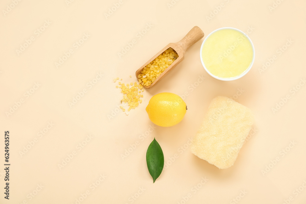 Bowl of lemon body scrub with sea salt and bath sponge on beige background