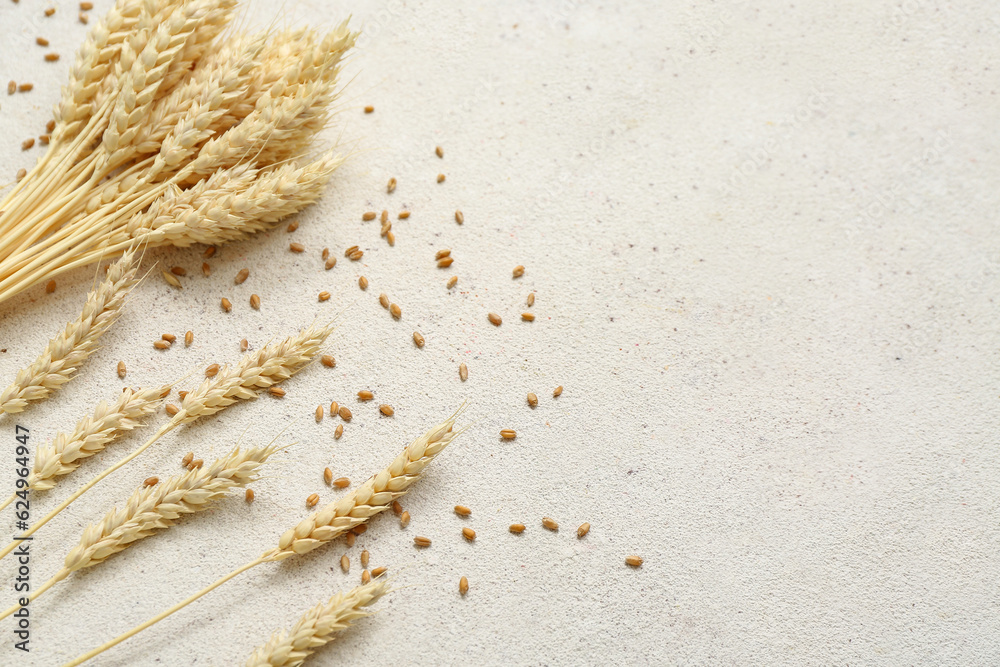 Wheat ears and grains on white table