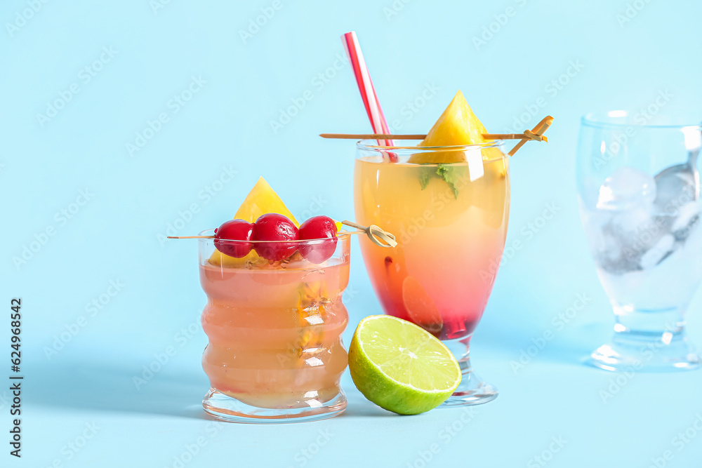 Glasses of tasty mai tai cocktail on blue background