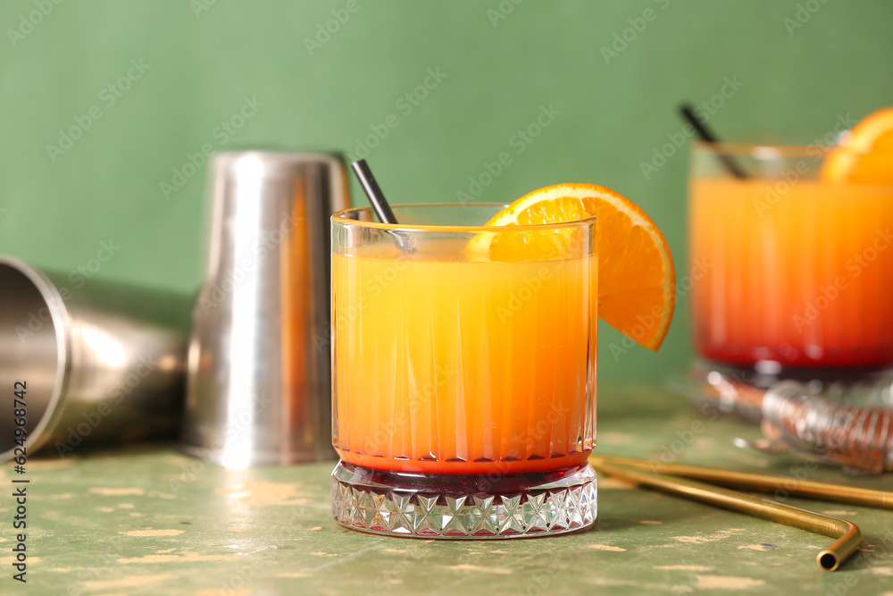 Glass of tasty mai tai cocktail on green background