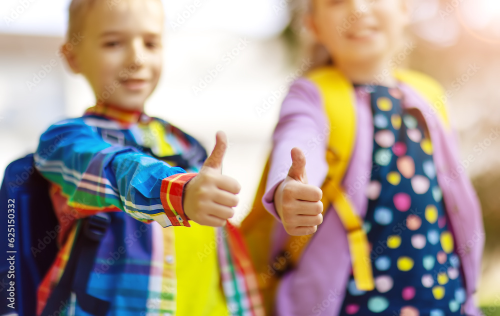 Boy and girl standing near the school with thumbs up.