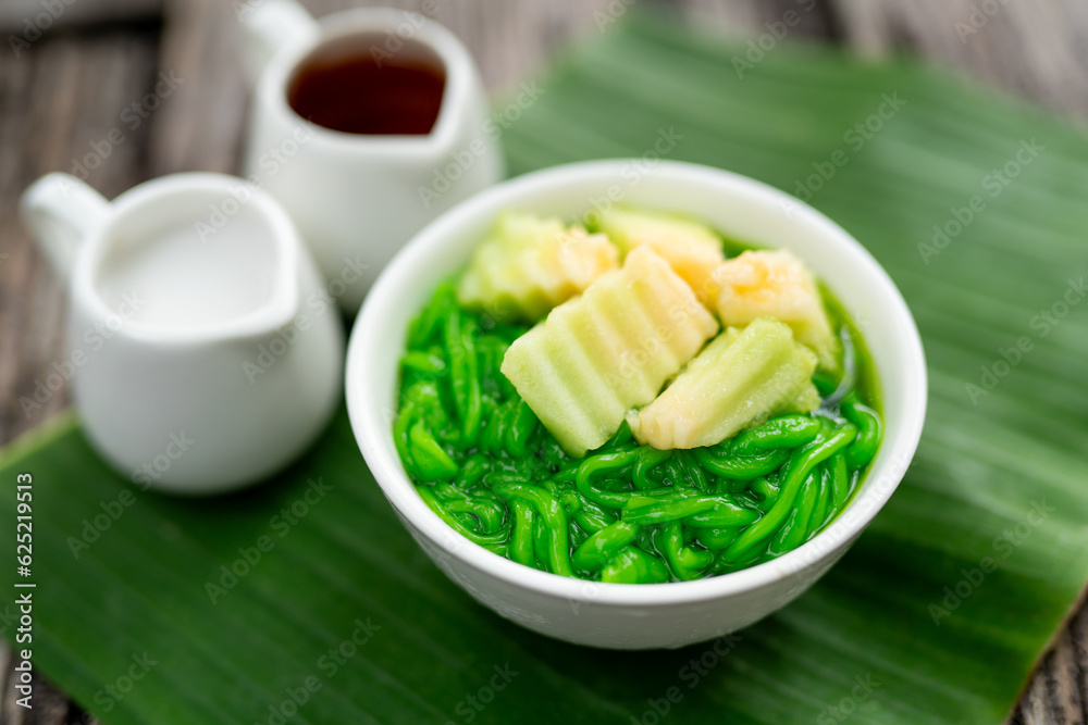 Close up of Lod Chong, fresh coconut milk, sugar cane decorated with pandan leaves followed by green