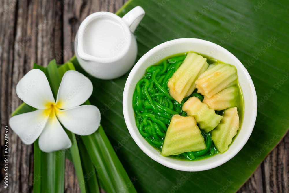 Top view of Lod Chong Thai dessert with coconut milk and pandan leaf on the wood background.