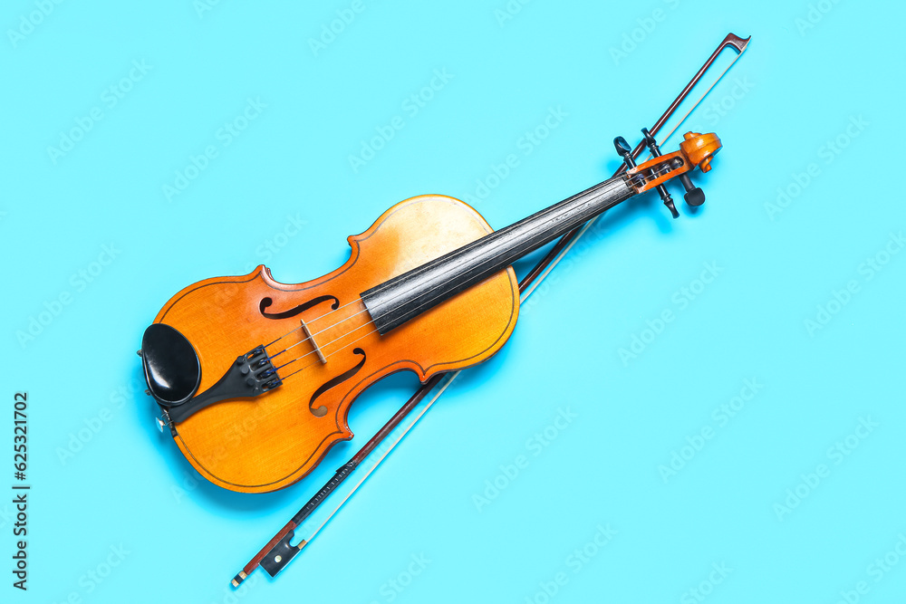 Beautiful violin with bow on color background