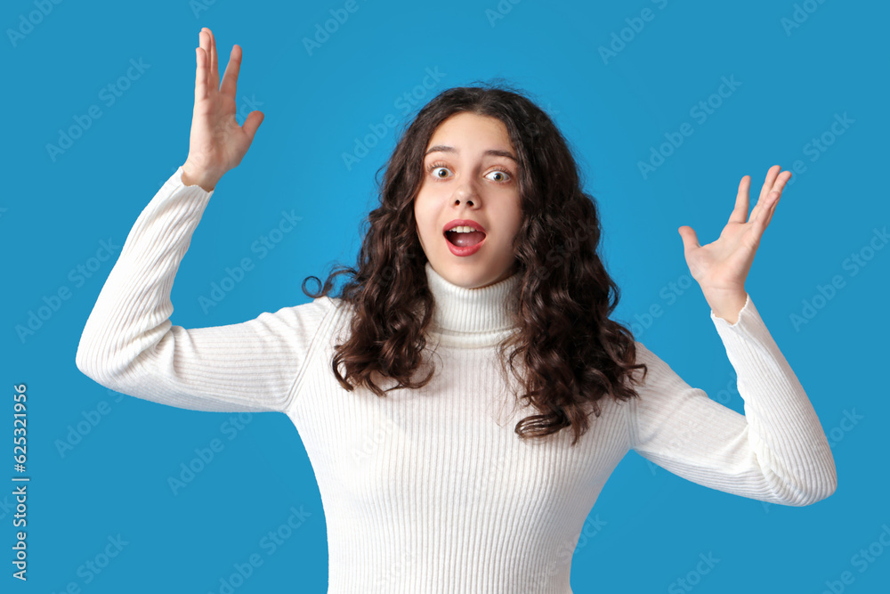 Surprised teenage girl on blue background