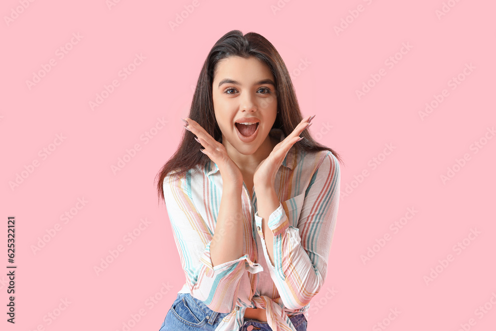 Surprised young woman in shirt on pink background