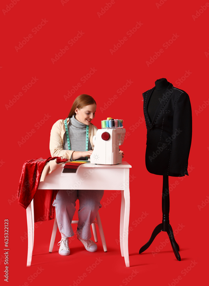 Female dressmaker sewing at table on red background