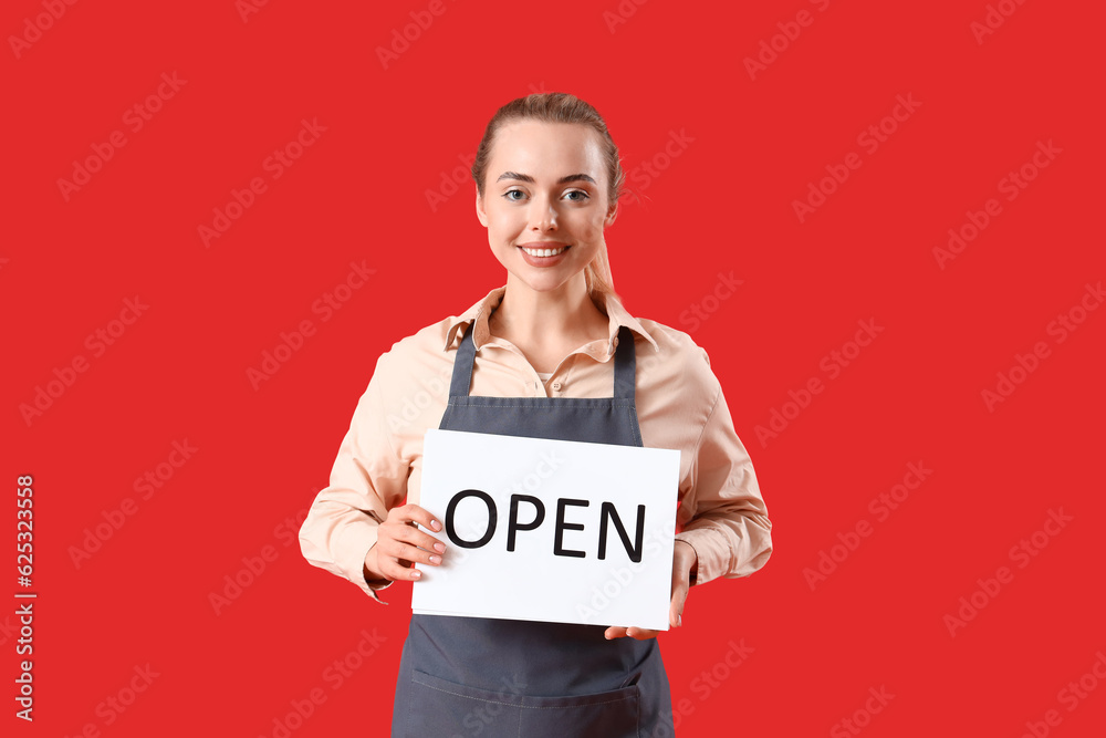 Young barista with open sign on red background