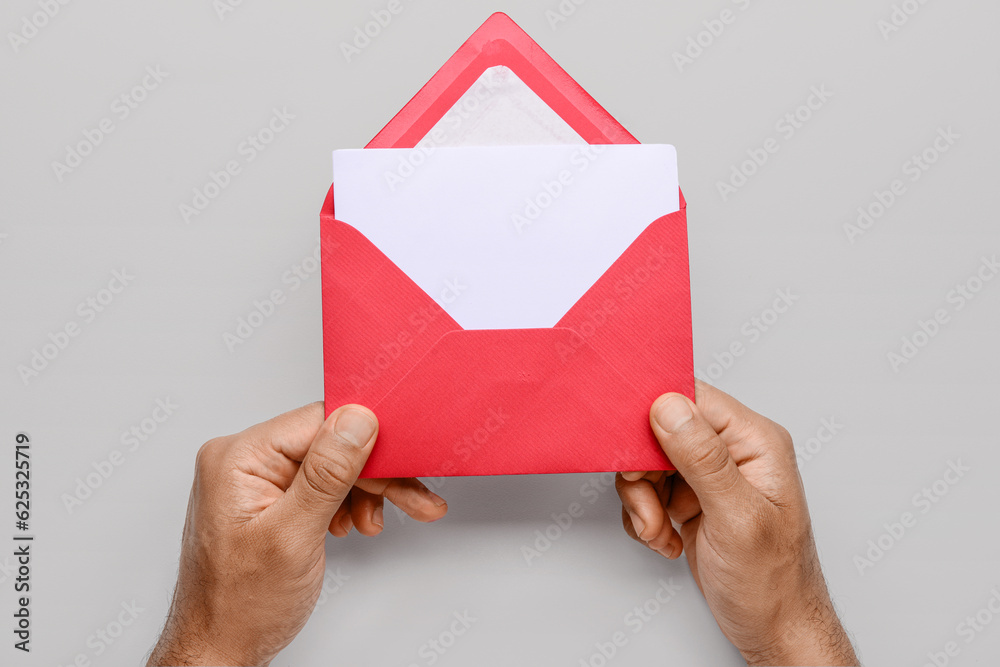 Male hands with envelope and blank card on white background, closeup