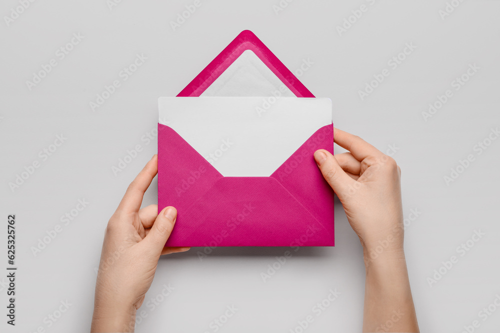 Female hands with envelope and blank card on white background, closeup