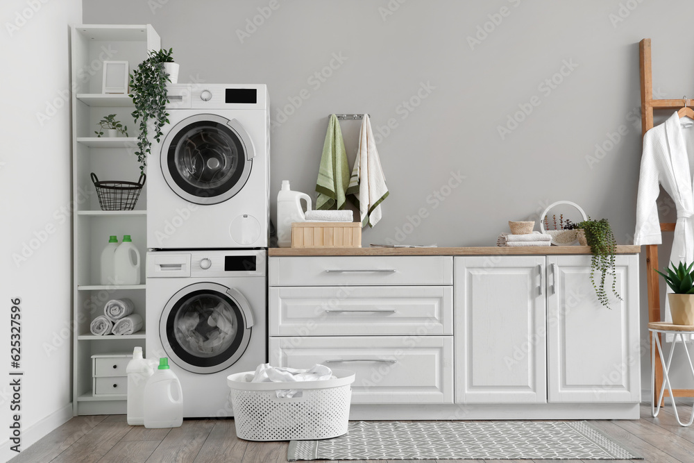 Laundry room with washing machines and white counters