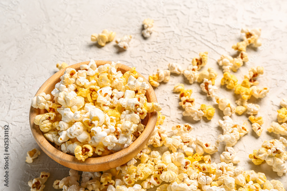 Bowl with tasty popcorn on white background