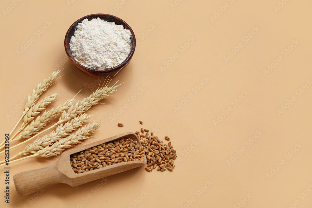 Wheat flour in bowl, scoop with grains and spikelets on brown background