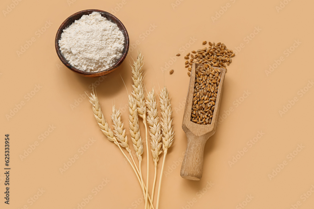 Wheat flour in bowl, scoop with grains and spikelets on brown background