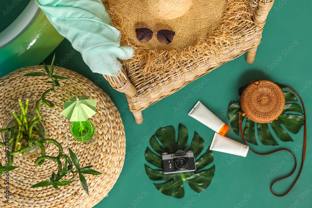 Beach accessories, sunscreen cream and glass of cocktail on color background