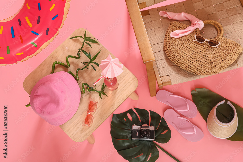 Beach accessories, bottle of drink and chair on pink background