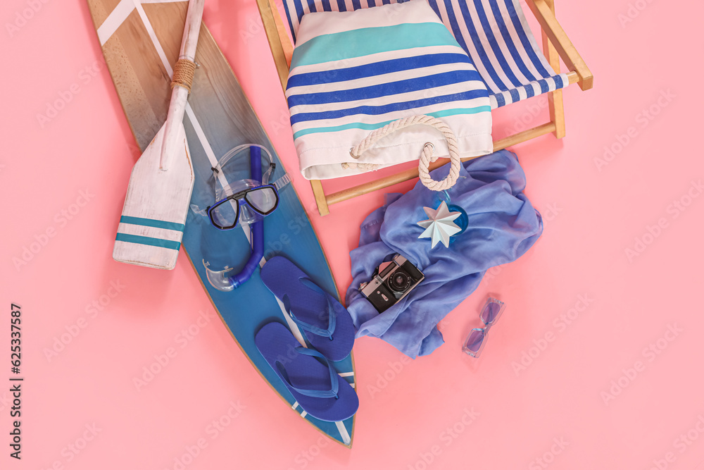 Set of beach accessories and photo camera on pink background