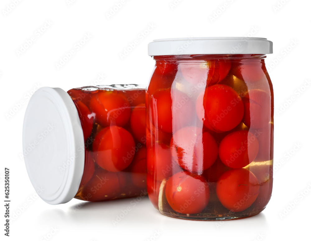 Jars with canned tomatoes on white background