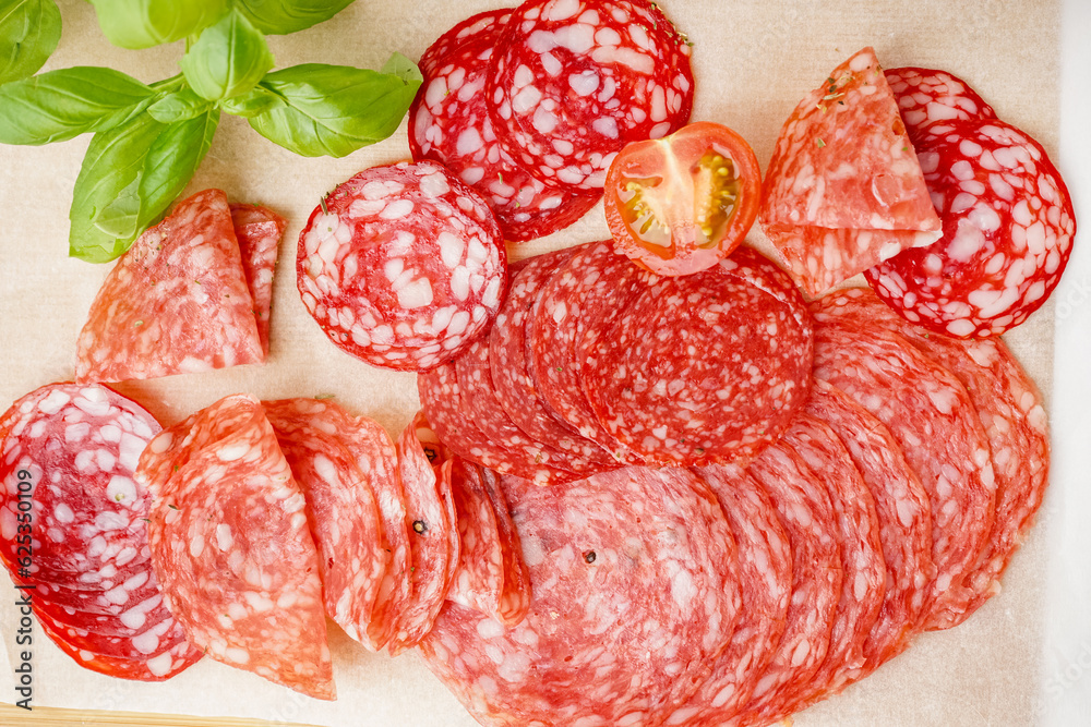 Slices of tasty salami on table