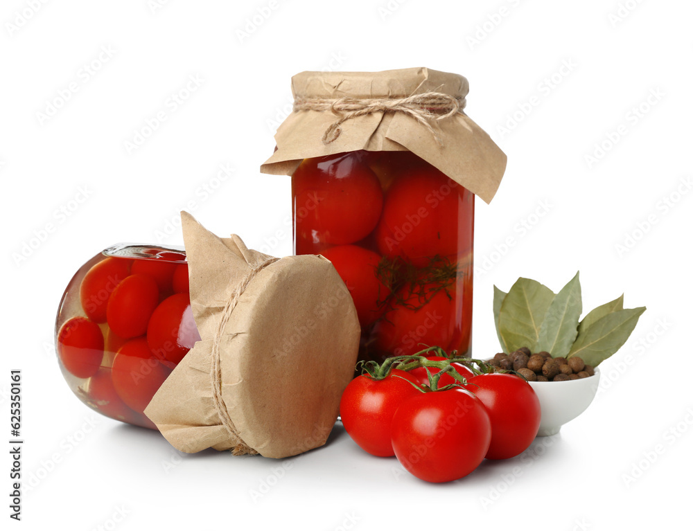 Jars with canned tomatoes and peppercorn on white background