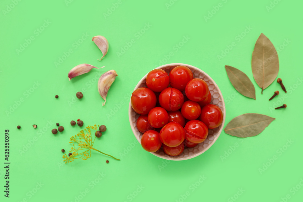 Bowl with canned tomatoes, peppercorn and garlic on green background