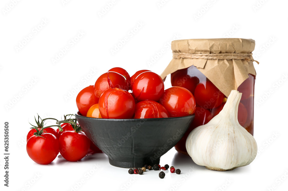 Bowl and jar with canned tomatoes on white background