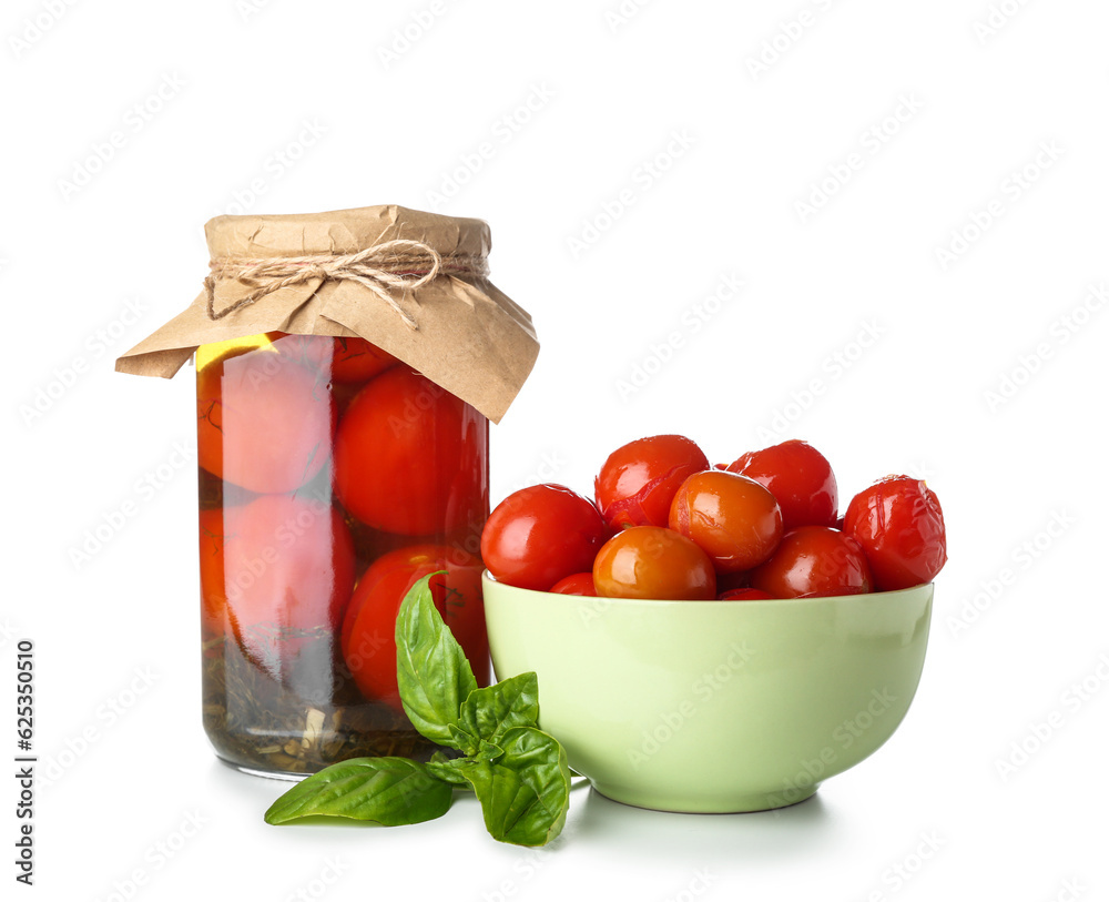 Bowl and jar with canned tomatoes on white background