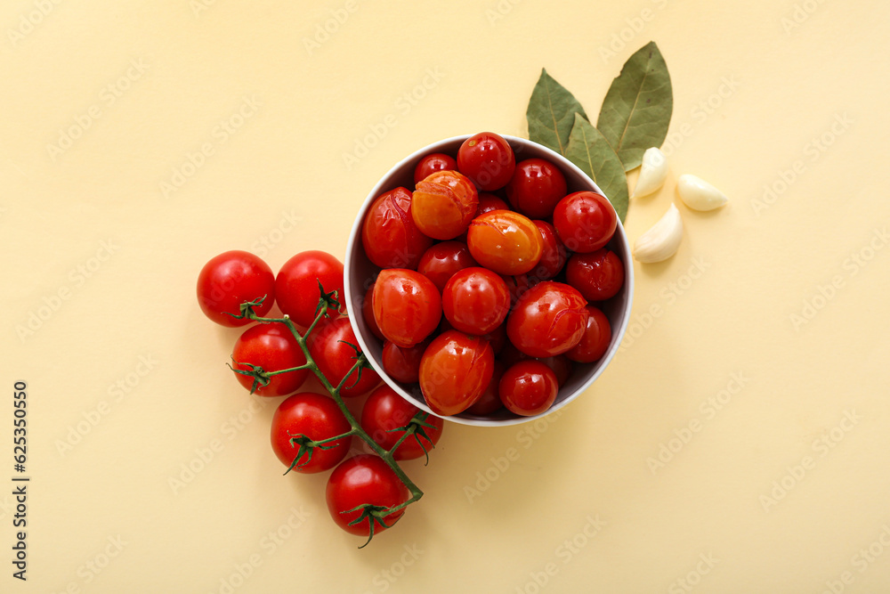 Bowl with canned tomatoes and garlic on yellow background