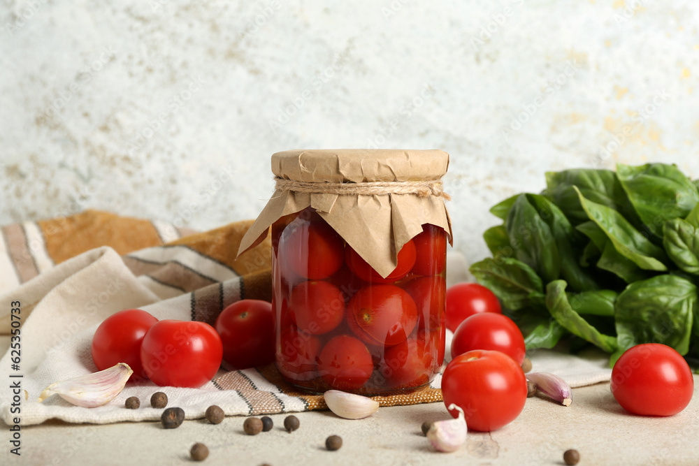 Jar with canned tomatoes, garlic and basil on white background