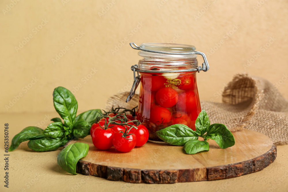 Jar with canned tomatoes and basil on brown background